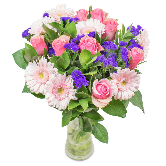 This stately bouquet, shown in a pristine clear glass vase against a luminous white background, is a celebration of floral finesse inspired by the refined beauty of St James's. The composition features 7-9 pink roses-ranging from blushing buds to partially opened blooms-arranged to highlight their elegant spiral centres and sophisticated presence. Intermingled are 5-7 pale pink gerbera daisies, their broad, radiating petals and gentle, creamy centres mirroring the clean lines of the classic Georgian terraces nearby. Striking injections of vivid purple statice or limonium add a lively contrast and textured drama, underscoring the richness of the arrangement's palette. A lush bed of deep green foliage anchors the bouquet, much like the well-groomed greenery of St James's Square, giving the bouquet fullness and emphasizing its freshness. The stems are neatly arranged within a transparent vase filled with clear water, visible and vibrant, suggesting impeccable freshness and local delivery straight from Flower Delivery St James's. An ideal gift for birthdays, anniversaries, or Mother's Day, or as an elegant accent for a Mayfair or Westminster home, this timeless bouquet conveys celebration, affection, and a touch of regal charm.