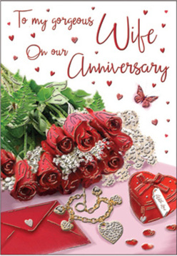 The artwork on this anniversary card unfolds like an intimate love letter styled with the quiet sophistication of St James's. In the centre, a posy of crimson roses commands attention, each flower lush and full, with swirling petals that look almost tangible, as though you could feel their velvety softness and inhale their delicate perfume. Fresh greenery frames the roses, adding movement and contrast, making the flowers appear to spill gently forward from the card, much like a bouquet laid out on a table near St James's Park. Scattered around this floral focal point are luxurious romantic touches: a rich scarlet jewellery box tied with a smooth ribbon, its edges catching the light; a golden necklace shaped into intertwined hearts, resting in a relaxed curve that suggests it has just been taken from its box; and tiny sparkling decorations that glimmer like confetti in the warm glow. The script on the card is elegantly handwritten, its flowing lines weaving among a cascade of miniature red hearts, echoing the passionate hue of the roses. The entire composition is bathed in soft, inviting lighting, reminiscent of evening light over Regent Street, giving the scene a gentle radiance rather than bright glare. Surfaces appear smooth and finely finished, from the satin-like background to the polished metal of the jewellery, conjuring a feeling of understated luxury. Every element is arranged as if by an experienced florist or stylist who understands how to balance colour, texture, and sentiment, just as Flower Delivery St James's balances classic romance with modern London elegance for local anniversary deliveries. The result is an image that beautifully honours cherished anniversaries and shared futures in this distinguished corner of the city.