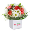 This radiant bouquet is pure delight, styled by skilled hands from St James's and nestled neatly in a classic white gift bag. A joyful assembly of coral and red carnations, their petals plush and ruffled, bursts with warmth like a cheerful market stall on a spring morning near St James's Square. White daisies glow with friendly yellow-green centers, harmonizing gently with gossamer clouds of baby's breath that flutter between the more dramatic blooms. Small purple buds add a secretive spark, inviting the eye to linger, much as one would at a favourite café tucked along King Street. Wrapped in fresh, deep green leaves, the arrangement feels full and carefully tended. Presented in a crisp white gift bag, it's perfect for delivery throughout SW1, ready to impart a sense of happiness and care-whether celebrating a birthday, sharing a congratulatory note, or simply bringing a touch of local beauty to someone's day in the heart of St James's.